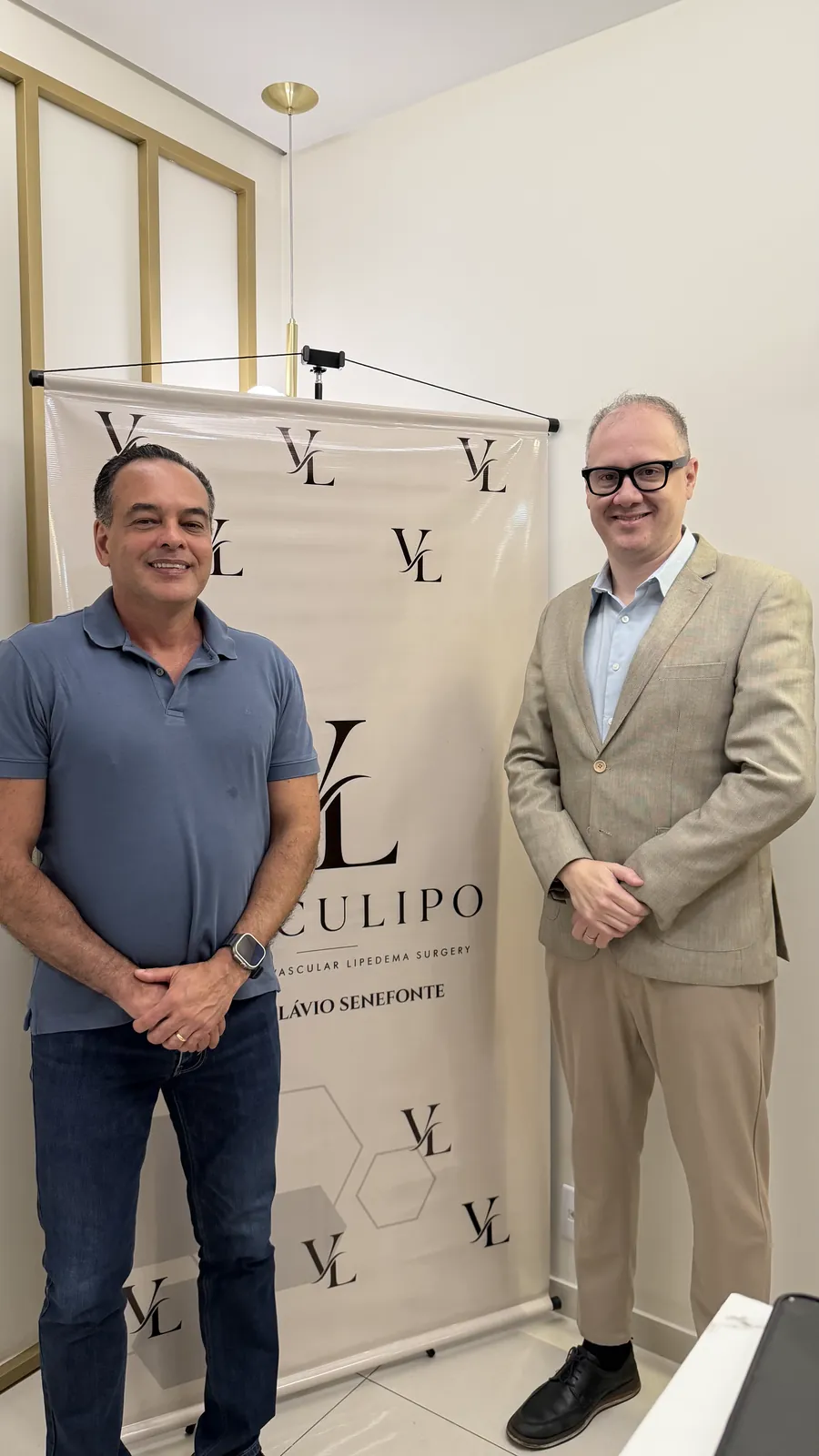 Dr. Flávio Senefonte e o Dr. Roney Hans diante do banner Vasculipo